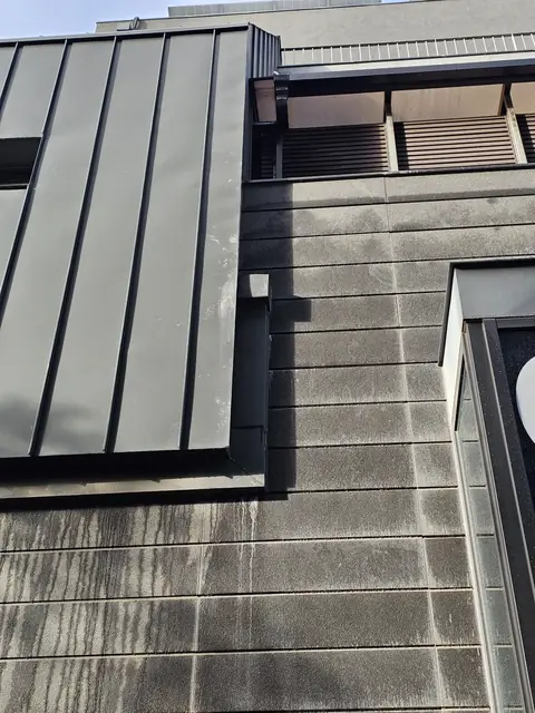 패널 끝 박스 아래로 배관이 보이지 않고 빗물 흐른 자국이 보이는 외벽 - 시공 전