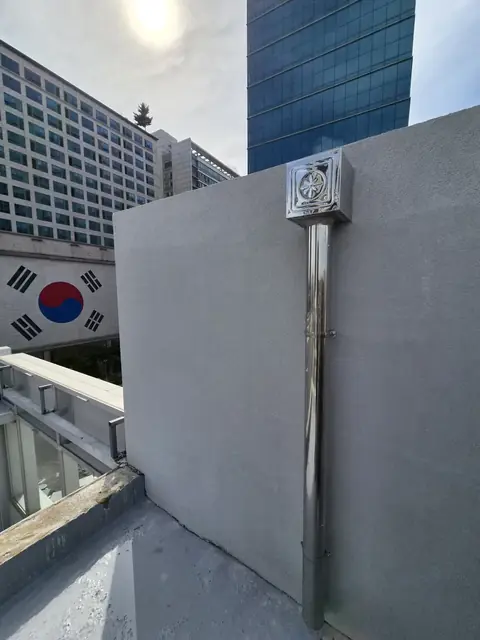 옥상 벽면에 고정된 스텐 배관과 상단 캡 - 옥상우수관교체 현장